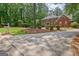 Spacious driveway leading to a brick home surrounded by lush greenery at 111 Biltmore Trce, Peachtree City, GA 30269