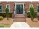 Elegant front entrance with brick steps, a black double door, and manicured landscaping at 111 Biltmore Trce, Peachtree City, GA 30269
