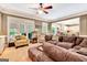 Comfortable living room featuring a large sofa, ceiling fan, and natural light from the windows at 111 Biltmore Trce, Peachtree City, GA 30269