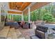 Covered outdoor patio featuring a kitchen and fire pit with view of the wooded yard at 111 Biltmore Trce, Peachtree City, GA 30269