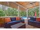 Covered outdoor patio with comfortable seating and wooded views at 111 Biltmore Trce, Peachtree City, GA 30269