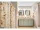 Bright bathroom with a double sink vanity, mirrors, soft lighting, and a patterned shower curtain at 29 Clark Pl, Whitesburg, GA 30185