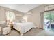Calm bedroom with a queen-sized bed, neutral decor, and sliding glass door to the patio at 29 Clark Pl, Whitesburg, GA 30185