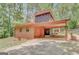 Exterior showcasing unique architectural details, attached carport, and a serene wooded backdrop at 29 Clark Pl, Whitesburg, GA 30185