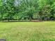 Expansive backyard with lush lawn, mature trees, and wooden fence, perfect for outdoor activities and enjoying nature's serenity at 377 Parker Rd, Mcdonough, GA 30252