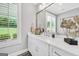 Bright bathroom with a double vanity, white marble countertop, decorative gold art and a view from the window at 377 Parker Rd, Mcdonough, GA 30252