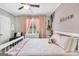 Light-filled bedroom features pink walls, floral accents, a charming white bed frame, and soft, neutral carpeting at 377 Parker Rd, Mcdonough, GA 30252