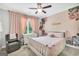 Light-filled bedroom features pink walls, floral accents, a charming white bed frame, and soft, neutral carpeting at 377 Parker Rd, Mcdonough, GA 30252