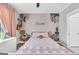 Light-filled bedroom features pink walls, floral accents, a charming white bed frame, and soft, neutral carpeting at 377 Parker Rd, Mcdonough, GA 30252