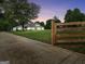 Long driveway and fenced lawn of well-manicured home at dusk at 377 Parker Rd, Mcdonough, GA 30252