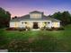 Charming home with a manicured lawn, rocking chair front porch, and inviting curb appeal at dusk at 377 Parker Rd, Mcdonough, GA 30252