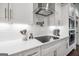 Bright kitchen features white cabinets, subway tile backsplash, quartz countertops, and stainless steel hood at 377 Parker Rd, Mcdonough, GA 30252