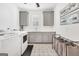 Well-organized laundry room with gray cabinetry, patterned tile flooring, and modern appliances at 377 Parker Rd, Mcdonough, GA 30252