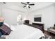 Bright main bedroom featuring a tray ceiling, ceiling fan, and dark wood furnishings at 377 Parker Rd, Mcdonough, GA 30252