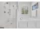 Bathroom featuring a walk-in shower with bench and a soaking tub with window at 377 Parker Rd, Mcdonough, GA 30252