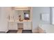 This bathroom has a double vanity with white cabinets, framed mirrors, and a soaking tub at 2990 Haynes Club Cir, Grayson, GA 30017