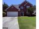Charming two-story brick home with attached two car garage and well-manicured front lawn at 2990 Haynes Club Cir, Grayson, GA 30017