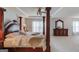Elegant main bedroom with a dark wood canopy bed, ceiling fan, and dresser at 2990 Haynes Club Cir, Grayson, GA 30017