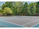 Well-maintained tennis courts with nets, benches, lighting, and a fenced perimeter surrounded by lush greenery at 2990 Haynes Club Cir, Grayson, GA 30017