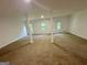 Wide angle view of large carpeted basement featuring white support beams and natural light at 172 Oak Forest Se Dr, Smyrna, GA 30082