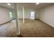 Partially finished basement with carpeted floors, support beams, and access to unfinished areas at 172 Oak Forest Se Dr, Smyrna, GA 30082
