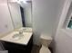 Bathroom featuring a mirror, sink with cabinet, toilet, and window at 172 Oak Forest Se Dr, Smyrna, GA 30082