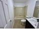 Bathroom featuring a tub-shower, vanity, toilet, and neutral colored tile at 172 Oak Forest Se Dr, Smyrna, GA 30082