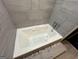 A modern white bathtub with gray tile surround and tiled floor at 172 Oak Forest Se Dr, Smyrna, GA 30082