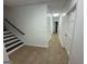 Hallway with tile flooring leading to multiple doors and a staircase with a black handrail at 172 Oak Forest Se Dr, Smyrna, GA 30082