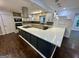 Modern kitchen with stainless steel appliances, a U-shaped island with a white countertop, and dark wood floors at 172 Oak Forest Se Dr, Smyrna, GA 30082