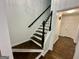 Staircase with hardwood steps and black railing and white trim at 172 Oak Forest Se Dr, Smyrna, GA 30082