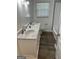Bathroom featuring a double sink vanity with carrara marble countertop, beadboard walls and wood-look flooring at 113 Ausband Dr, Mcdonough, GA 30253