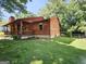 Side exterior view of home with wooden siding and ample backyard lawn space at 6698 Cameron Rd, Morrow, GA 30260