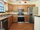 Well-lit kitchen featuring wood cabinetry, stainless steel appliances, and laminate countertops at 6698 Cameron Rd, Morrow, GA 30260