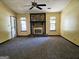 Living room featuring a decorative stone fireplace, neutral carpeting and two windows at 6698 Cameron Rd, Morrow, GA 30260