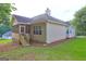 Back exterior of home shows back patio, lush landscaping, and traditional siding at 221 Ashley Oaks Dr, Mcdonough, GA 30253