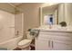 Bathroom featuring a white vanity with stylish fixtures, toilet, and shower-tub combo at 221 Ashley Oaks Dr, Mcdonough, GA 30253