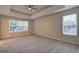 Spacious bedroom featuring tray ceiling, ceiling fan and bright windows at 221 Ashley Oaks Dr, Mcdonough, GA 30253