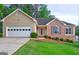 Charming home featuring a two-car garage, well-manicured lawn, and a mix of brick and siding accents at 221 Ashley Oaks Dr, Mcdonough, GA 30253