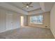 Bright main bedroom featuring a trey ceiling with ceiling fan, neutral walls, and carpeted floors at 221 Ashley Oaks Dr, Mcdonough, GA 30253