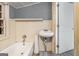 Bathroom featuring a bathtub, sink and cream-colored paneled walls at 5166 Avery Sw St, Covington, GA 30014