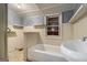 Bathroom featuring a bathtub, sink and grey and cream-colored paneled walls at 5166 Avery Sw St, Covington, GA 30014