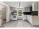 Well-lit kitchen with white cabinets, stainless steel appliances, and gray flooring at 5166 Avery Sw St, Covington, GA 30014
