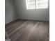 Bedroom featuring neutral decor, new flooring, and natural light from a large window at 2615 Old South Ct, Jonesboro, GA 30236