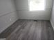 Bedroom featuring neutral decor, new flooring, and natural light from a large window at 2615 Old South Ct, Jonesboro, GA 30236
