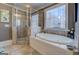 Bathroom featuring a luxurious soaking tub, tiled shower, and frosted windows, offering a spa-like retreat at 4128 Hunt Sw St, Covington, GA 30014