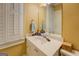 Bathroom featuring a white vanity with sink, framed mirror, and window with shuttered blinds at 4128 Hunt Sw St, Covington, GA 30014