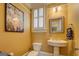 Cozy powder room with a pedestal sink, framed mirror, and decorative artwork at 4128 Hunt Sw St, Covington, GA 30014