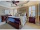Elegant bedroom featuring a ceiling fan, tray ceiling and beautiful furnishings, creating a serene and inviting space at 4128 Hunt Sw St, Covington, GA 30014