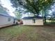 Overgrown backyard view featuring a detached garage, single story house and unkempt lawn at 1901 Clarke Ln, Decatur, GA 30035